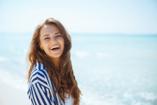 istock happy elegant woman on ocean shore having fun time 2063422034