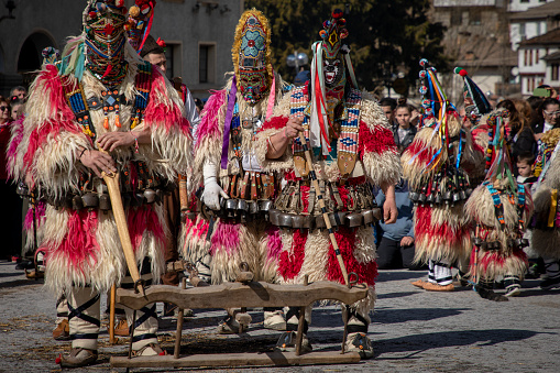 Shiroka Laka, Bulgaria - March 03, 2024: Masked men called Kukeri play and scare away evil spirits at the Pesponedelnik Masquerade Games Festival in Shiroka Laka, Bulgaria