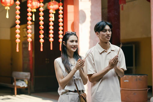 Lovely young Asian tourist couple enjoying their old town sightseeing, visiting a Chinese temple together.