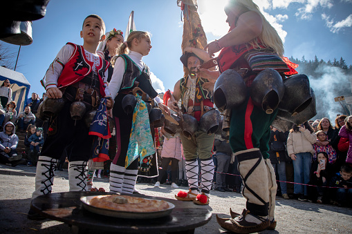 Shiroka Laka, Bulgaria - March 03, 2024: Masked men called Kukeri prepare for an exorcism ritual at the Pesponedelnik Masquerade Games Festival in Shiroka Laka, Bulgaria
