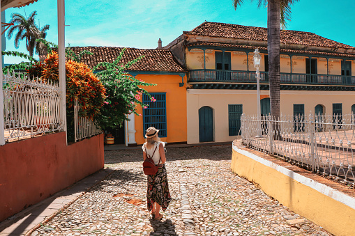 Young woman walking on a street of colonial town Trinidad, Cuba