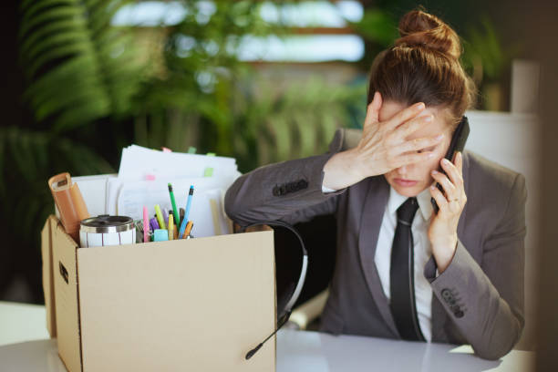 istock sad woman worker in green office talking on phone 2063451383