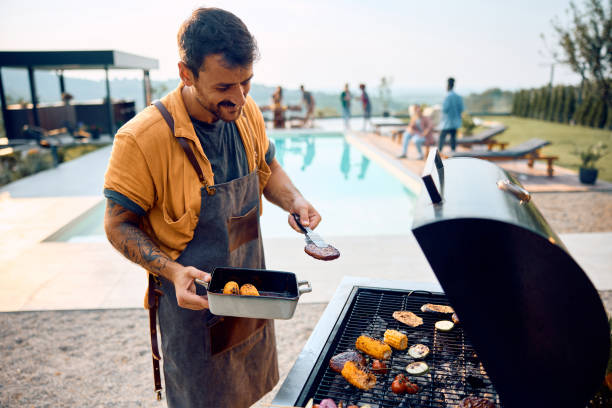istock Young happy man preparing barbecue by the pool. 2063453032