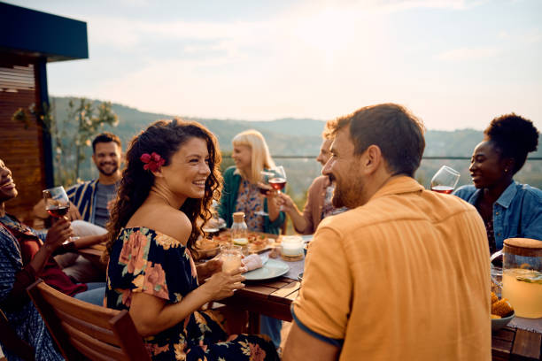 istock Happy couple talking while having lunch with friends at dining table on a patio. 2063453084
