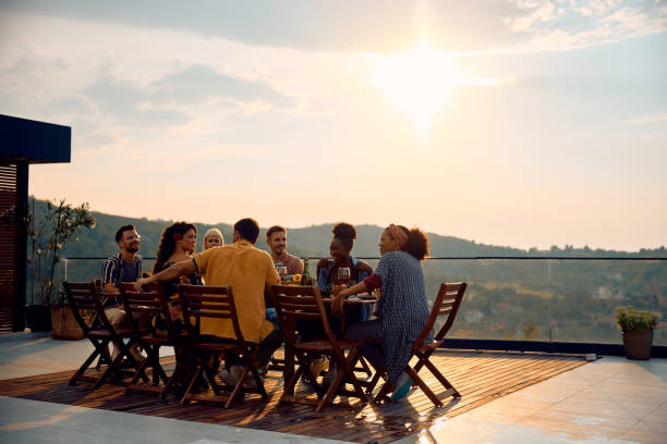 istock Multiracial group of friends having lunch at dining table on a patio. 2063454177