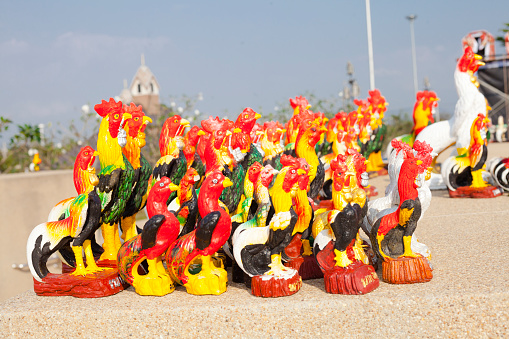 Grouped small, medium and tall seized  thai cockerel  figurines around and below King Naresuan monument in Lampang for  history  of marching King Naresuan the Great Through Lampang. Monument was made in 1992 To honor Her Majesty His Majesty the Queen's fifth anniversary in 1992 for independence of the nation and place of worship for the general public and source of historical study
