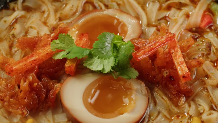 Asian fast food noodles with soybean sprouts, parsley and pickled or century egg close-up. Cooking instant noodles in boiling water with spices. Instant noodles, or instant ramen, is a type of food consisting of noodles sold in a precooked and dried block