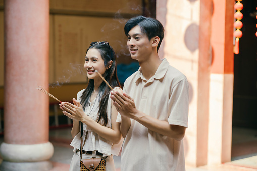Lovely young Asian tourist couple enjoying their old town sightseeing, visiting a Chinese temple together.