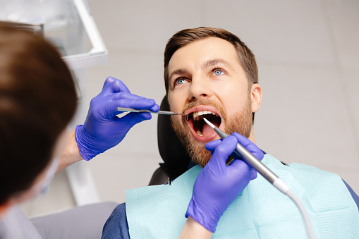 Man having teeth examined at dentists. Overview of dental caries prevention.