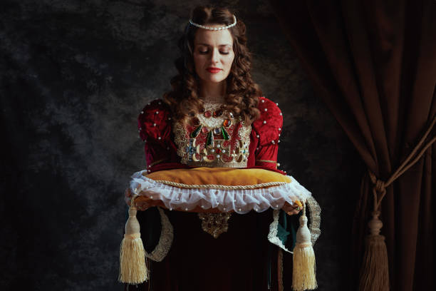 istock medieval queen in red dress with crown on pillow 2063501337