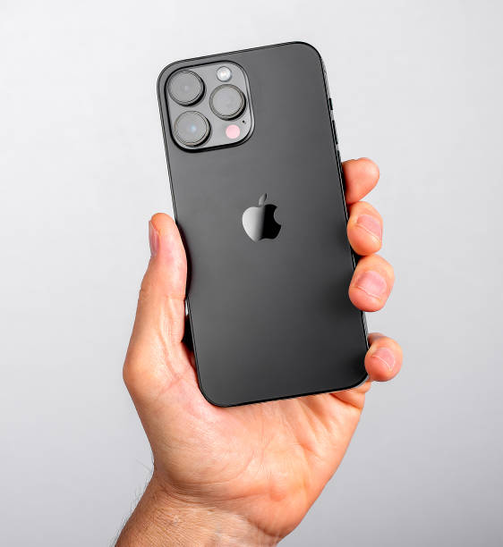 Hand holding iphone 14 pro max back side, view with camera block Berlin, Germany September 16 2023 Hand holding iphone 14 pro max back side, view with camera block camera covers pictures stock pictures, royalty-free photos & images