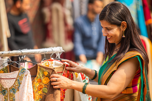 Smiling woman shopping at street market in Surajkund fair during weekend