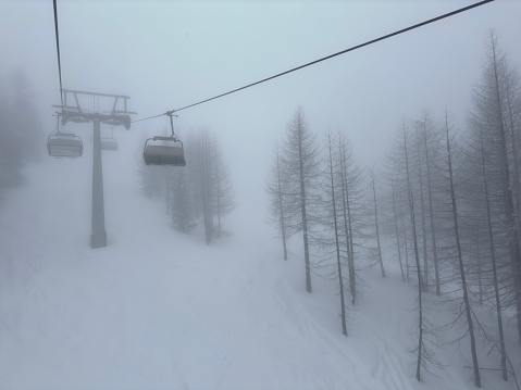 two cabs ropeway in heavy fog, mountain forest