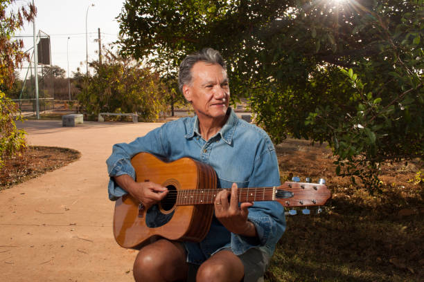 istock Man at a park playing his guitar 2063586018