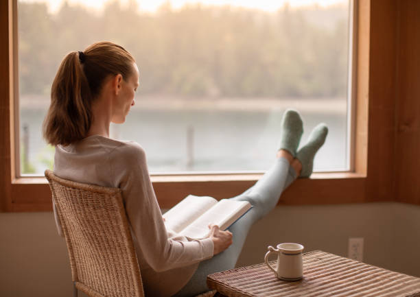 istock Woman reading book at home. 2063591368