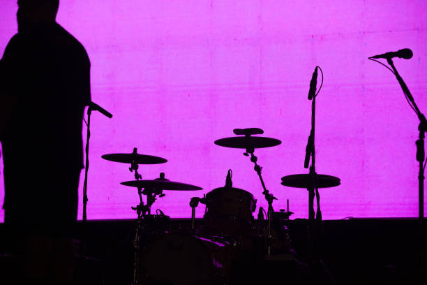 Silhouette of a drum with a pink background.