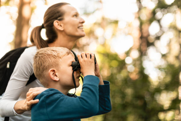 istock Mother and son looking for animals in the forest. 2063624959