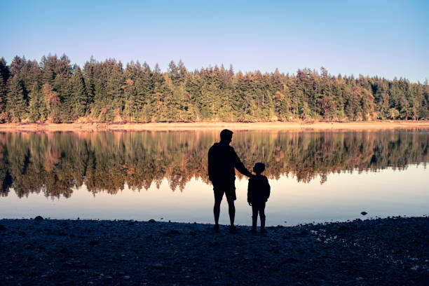 istock Father and son on the beach at sunset. 2063644261