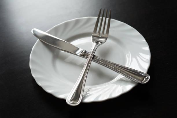 Cutlery on a black background. Fork, spoon, knife, plate.