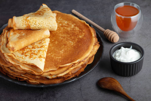 istock Stack of russian thin pancakes blini with fresh sour cream and honey 2063654348