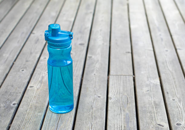 Blue Plastic Water Bottle with White Cap on Gray Background