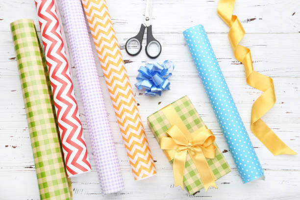 istock Rolls of craft papers with gift box and scissors on white wooden background 2063662927