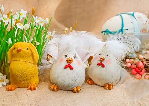 Baby yellow Easter toys chicks and eggs on a background of feathers. Festive greeting card. High quality photo