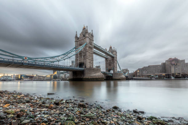 a low angle long exposure shot of the iconic tower bridge in london - london england financial district england long exposure - fotografias e filmes do acervo