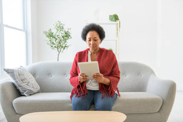 istock Black woman using tablet on living room at home 2063686826