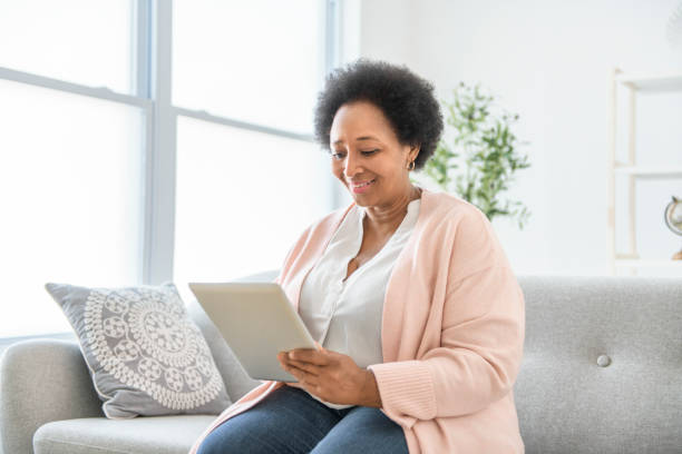 istock Black woman using tablet on living room at home 2063686838