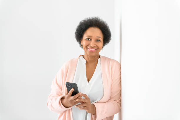 istock Black woman using cellphone on living room at home 2063686871
