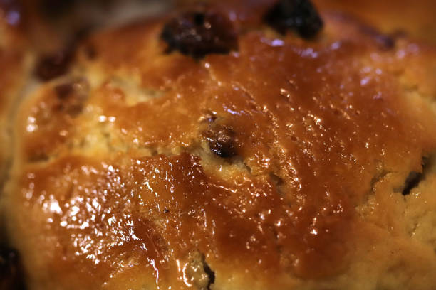 Homemade baked bun with raisins background. Macro closeup.