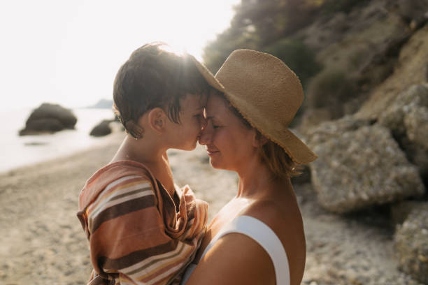 Photo of a young boy sharing some special moments with his mom, while spending some quality time together on the local beach