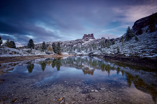 First snow at Lake Lago de Limides and Tofana di Rozes, with water reflection, Dolomites, Alps, South Tyrol, Italy during sunset