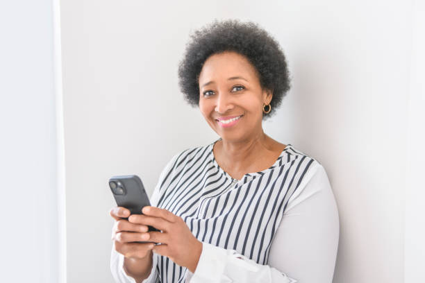 istock senior woman using her cellphone on white room 2063706408