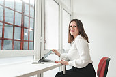 Portrait of businesswoman opening laptop