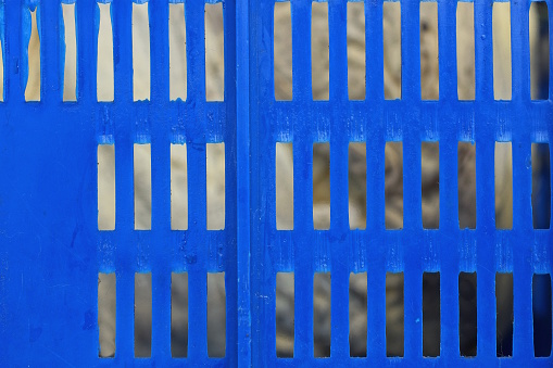 texture of part of a blue plastic lattice on a gray background