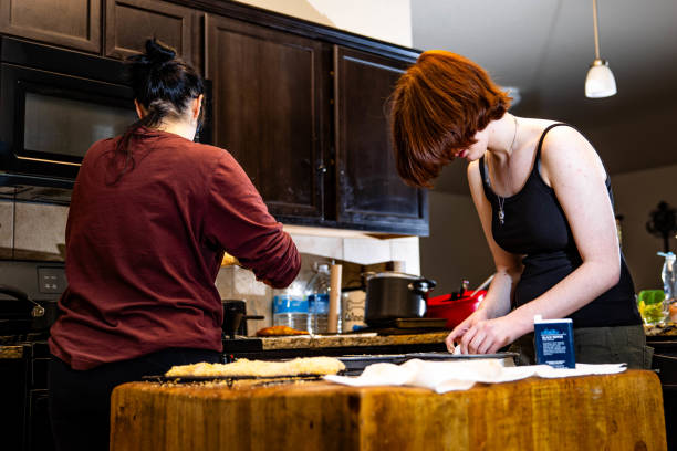 mother and daughter cooking in the kitchen. - home interior women domestic kitchen cabinet - fotografias e filmes do acervo