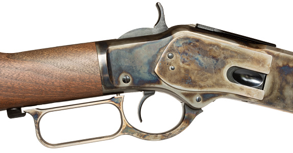Isolated lever action rifle and receiver that is color casehardened mounted on a wood stock and isolated.