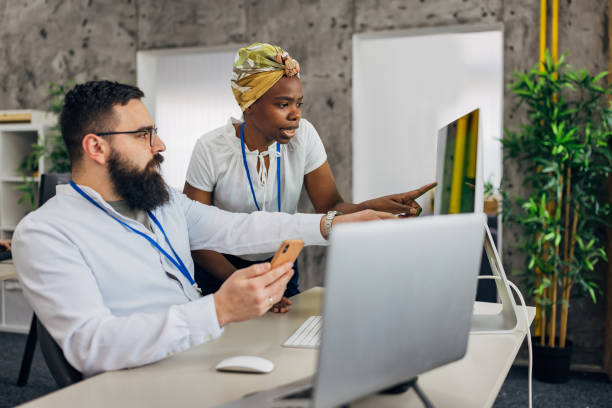 istock Man receives personalized cybersecurity training session from a specialist - confirms password using mobile phone 2063751275