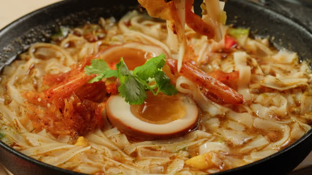 Asian fast food noodles with soybean sprouts, parsley and pickled or century egg close-up. Cooking instant noodles in boiling water with spices. Instant noodles, or instant ramen, is a type of food consisting of noodles sold in a precooked and dried block