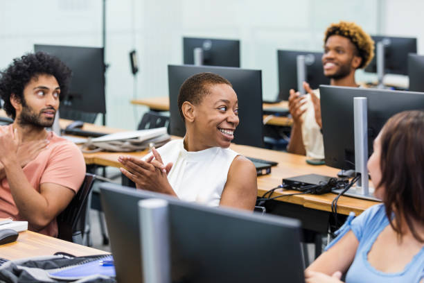 istock Classmates clap and look back to see who answered the professor's question 2063789092
