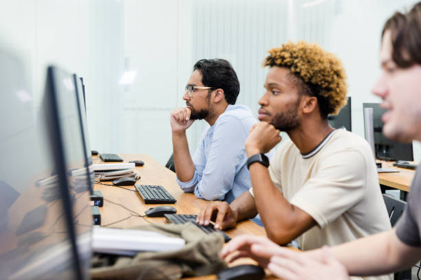 istock Young adult male engineers work diligently on a project alongside each other 2063789191