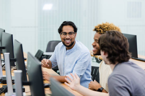 istock Young adult male tutor helps his classmates in the computer lab 2063789650