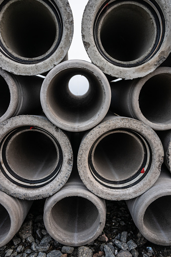 Large pile of concrete drain pipes at a construction site