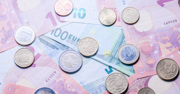istock Euro bank notes and coins on a table. 2063799842