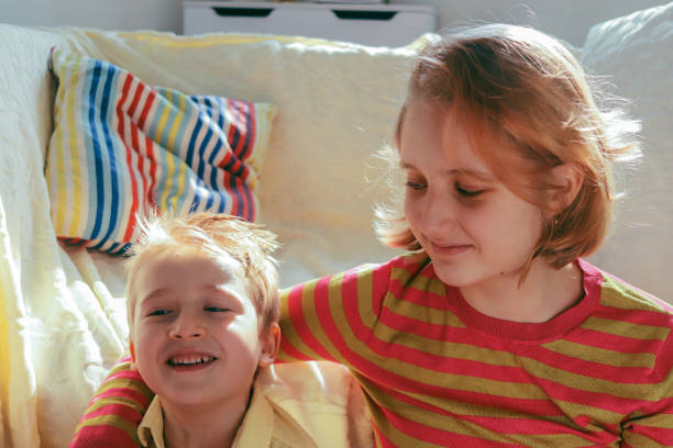 brother with his older sister in a bright room