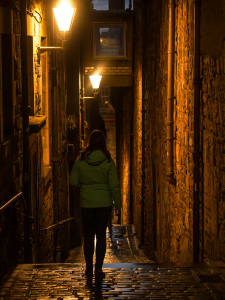 podążając za turystką, która odkrywa ciemną, wąską uliczkę w deszczowy wieczór - walking outdoors footpath single lane road zdjęcia i obrazy z banku zdjęć
