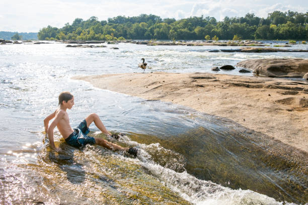 istock Teenage boy swimming in river rapids 2063854120
