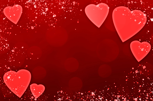 Red background with heart shapes, bokeh light and glittering particles. Can be used as a design for romantic or Valentine's day holiday greeting cards or posters.